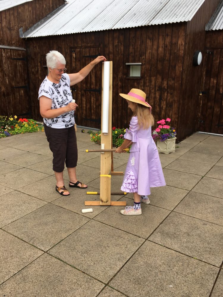 A Young girl dressed for the event having a go at Splat The Rat.